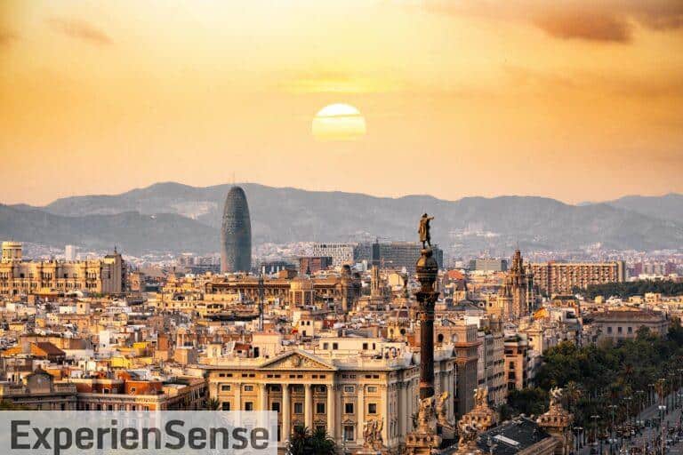 A stunning sunset view of the Barcelona skyline showcasing iconic landmarks and a warm, golden hour glow.